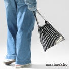 デニムスタイルの人物がMarimekko ストライプ柄ドローストリングバッグを持つ後ろ姿。カジュアルなコーディネートにマッチするブラック×ホワイトの巾着バッグ